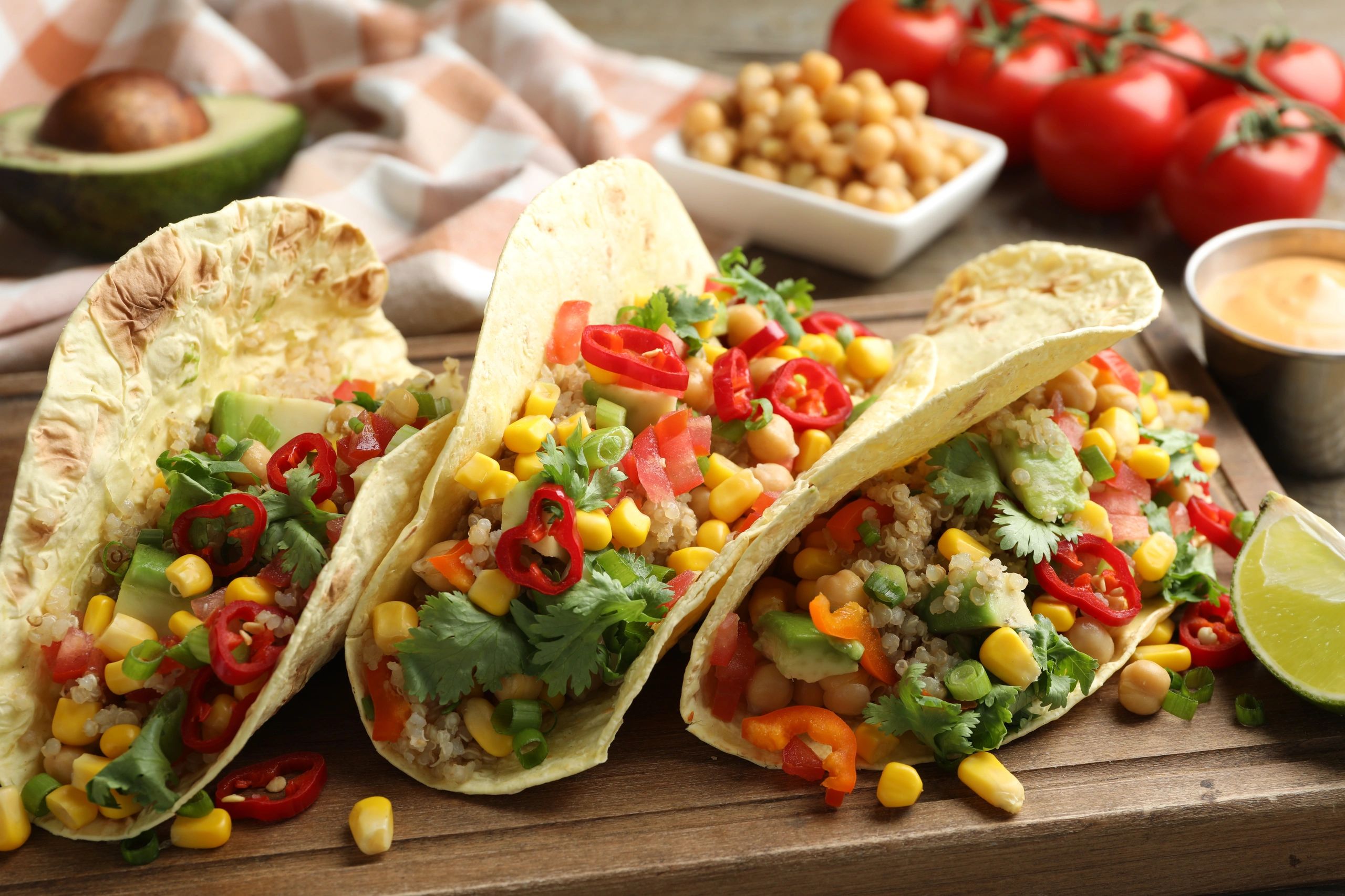 Vegetarian tacos with chickpeas, corn, and quinoa on a wooden table
